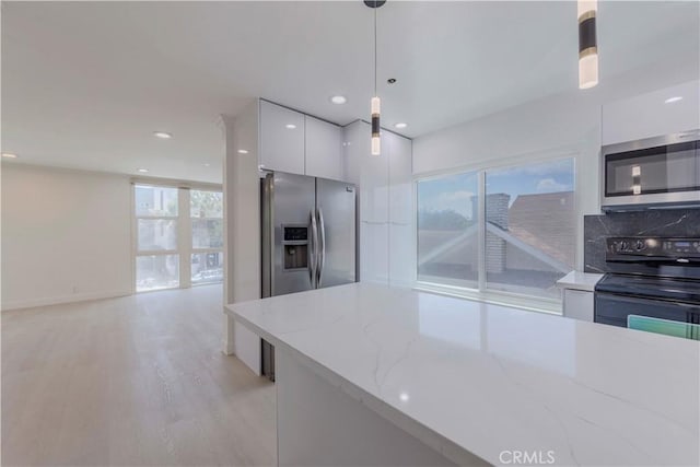 645 N Gramercy Pl, Los Angeles, CA 90004 - kitchen with stainless steel appliances, modern cabinets, white cabinetry, hanging light fixtures, and light wood-type flooring
