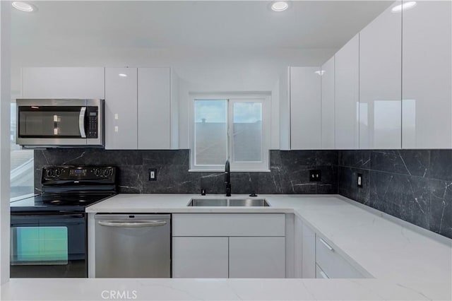 645 N Gramercy Pl, Los Angeles, CA 90004 - kitchen with stainless steel appliances, modern cabinets, white cabinets, light stone countertops, and recessed lighting