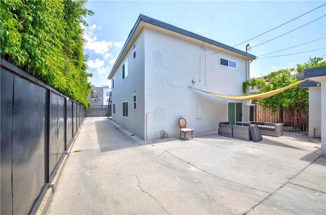645 N Gramercy Pl, Los Angeles, CA 90004 - rear view of house with an outdoor living space, a patio area, a fenced backyard, and stucco siding