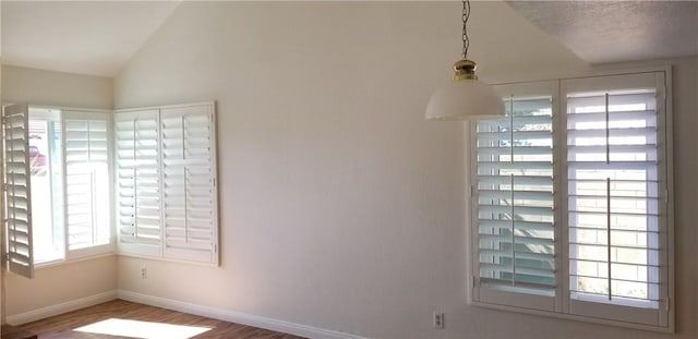 12180 Westerly Trl, Moreno Valley, CA 92557 - empty room with healthy amount of natural light, wood finished floors, and vaulted ceiling
