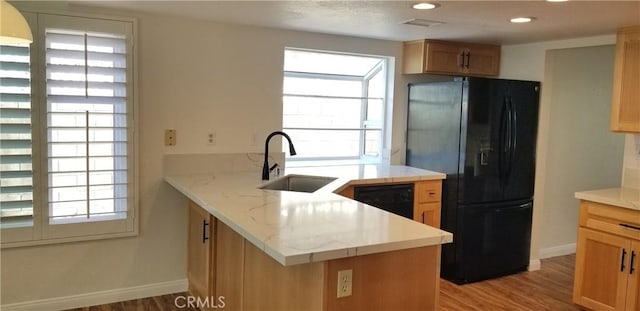 12180 Westerly Trl, Moreno Valley, CA 92557 - kitchen with black appliances, a peninsula, light wood-style flooring, recessed lighting, and light stone counters