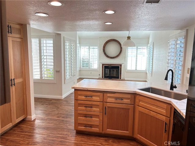 12180 Westerly Trl, Moreno Valley, CA 92557 - kitchen featuring a textured ceiling, dishwasher, dark wood finished floors, healthy amount of natural light, and a brick fireplace