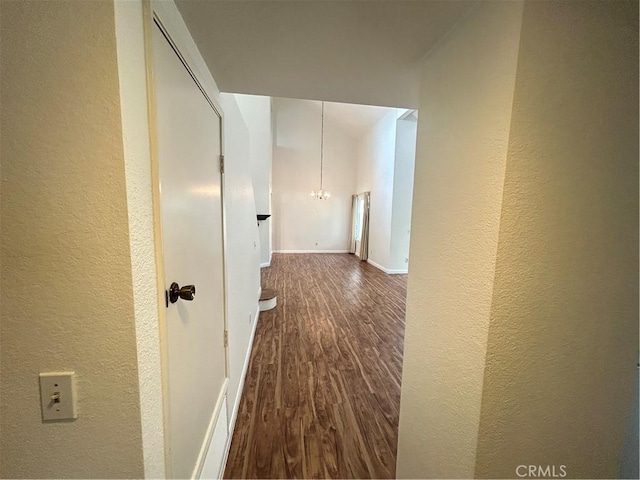 12180 Westerly Trl, Moreno Valley, CA 92557 - hall featuring a textured wall, dark wood-style flooring, and a chandelier