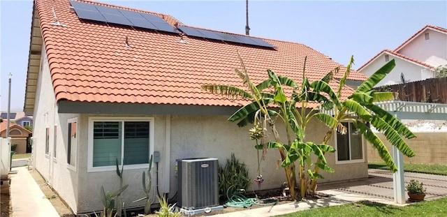 12180 Westerly Trl, Moreno Valley, CA 92557 - back of property featuring a tile roof, stucco siding, roof mounted solar panels, and a patio