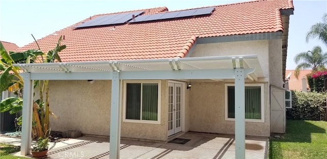 12180 Westerly Trl, Moreno Valley, CA 92557 - back of property featuring stucco siding, a pergola, solar panels, and a tiled roof