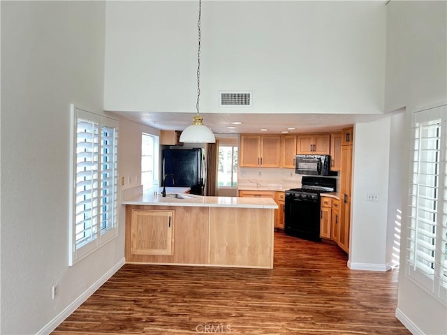 12180 Westerly Trl, Moreno Valley, CA 92557 - kitchen with black appliances, a high ceiling, light brown cabinets, a peninsula, and dark wood-style flooring