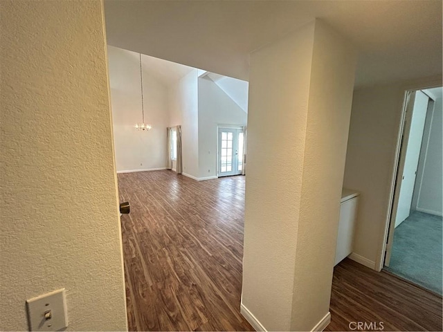 12180 Westerly Trl, Moreno Valley, CA 92557 - hall with dark wood finished floors, a textured wall, a chandelier, and vaulted ceiling