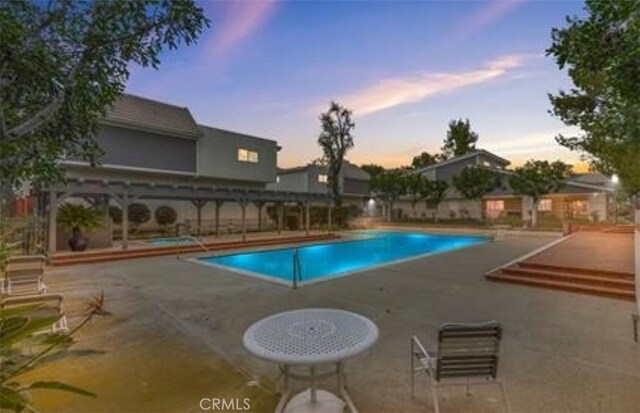 10201 Mason Ave Unit 34, Chatsworth, CA 91311 - pool at dusk featuring a patio area and a community pool