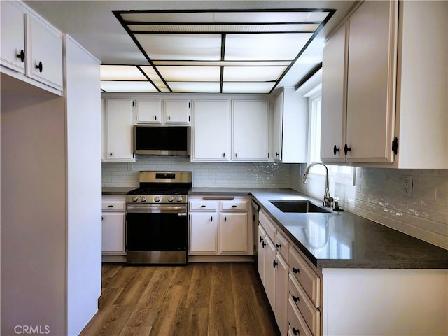10201 Mason Ave Unit 34, Chatsworth, CA 91311 - kitchen with stainless steel gas stove, dark wood-type flooring, backsplash, and dark countertops