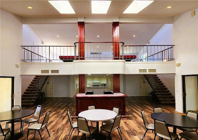 10201 Mason Ave Unit 34, Chatsworth, CA 91311 - dining room featuring wood finished floors, stairway, a towering ceiling, and a skylight
