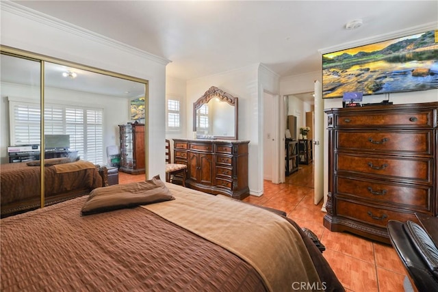 430 E 104th St, Los Angeles, CA 90003 - bedroom featuring light tile patterned floors, ornamental molding, and a closet