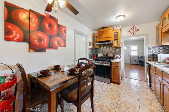 430 E 104th St, Los Angeles, CA 90003 - kitchen with tasteful backsplash, stainless steel appliances, glass insert cabinets, a ceiling fan, and light countertops