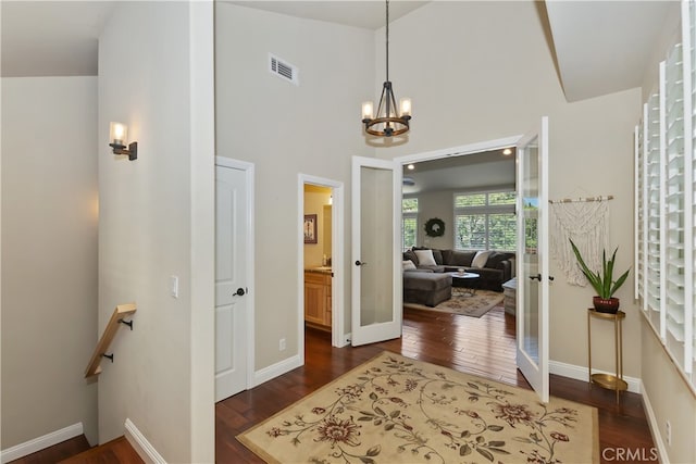 1179 Aleutian Dr, Lake Arrowhead, CA 92352 - hallway featuring dark wood-style floors, a chandelier, french doors, and an upstairs landing