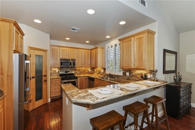 1179 Aleutian Dr, Lake Arrowhead, CA 92352 - kitchen with stainless steel appliances, a peninsula, dark wood-style floors, light stone countertops, and recessed lighting