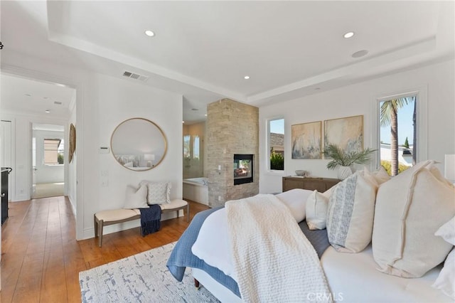 3201 4th Ave, Corona Del Mar, CA 92625 - bedroom with a raised ceiling, a multi sided fireplace, hardwood / wood-style floors, and recessed lighting