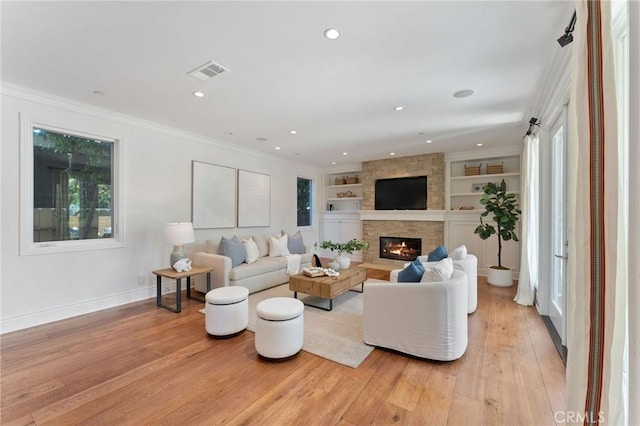 3201 4th Ave, Corona Del Mar, CA 92625 - living room featuring a stone fireplace, light wood-style floors, ornamental molding, built in shelves, and recessed lighting