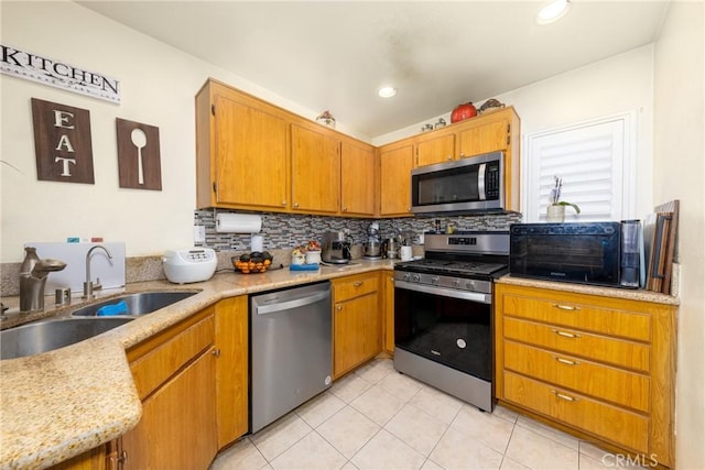23220 Colony Park Dr, Carson, CA 90745 - kitchen with stainless steel appliances, tasteful backsplash, light tile patterned flooring, and brown cabinetry