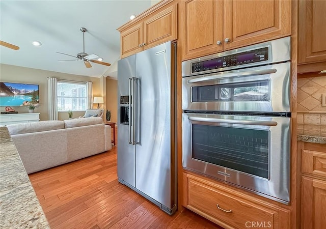 10424 Gloria Ave, Granada Hills, CA 91344 - kitchen with appliances with stainless steel finishes, a ceiling fan, light wood-style flooring, light countertops, and open floor plan