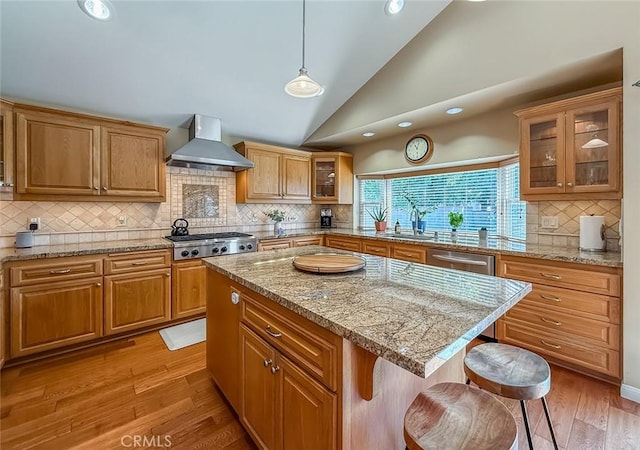 10424 Gloria Ave, Granada Hills, CA 91344 - kitchen with wall chimney exhaust hood, stainless steel appliances, lofted ceiling, decorative backsplash, and light wood finished floors