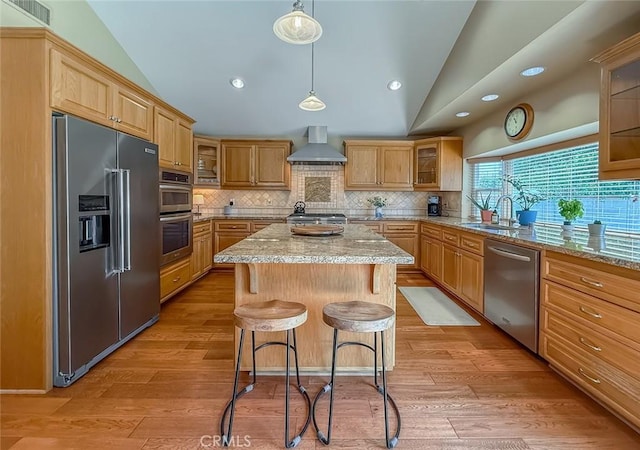 10424 Gloria Ave, Granada Hills, CA 91344 - kitchen with appliances with stainless steel finishes, lofted ceiling, wall chimney range hood, a kitchen island, and backsplash