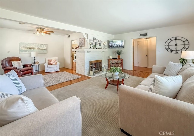 10424 Gloria Ave, Granada Hills, CA 91344 - living room with wood finished floors, a ceiling fan, and a brick fireplace