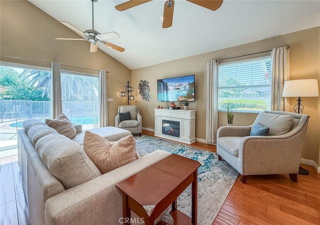10424 Gloria Ave, Granada Hills, CA 91344 - living area with vaulted ceiling, ceiling fan, light wood-style floors, and a glass covered fireplace