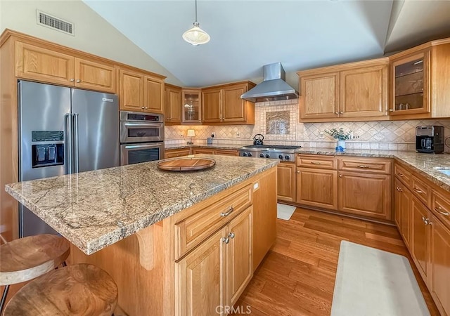 10424 Gloria Ave, Granada Hills, CA 91344 - kitchen with wall chimney range hood, lofted ceiling, appliances with stainless steel finishes, light wood-style flooring, and backsplash