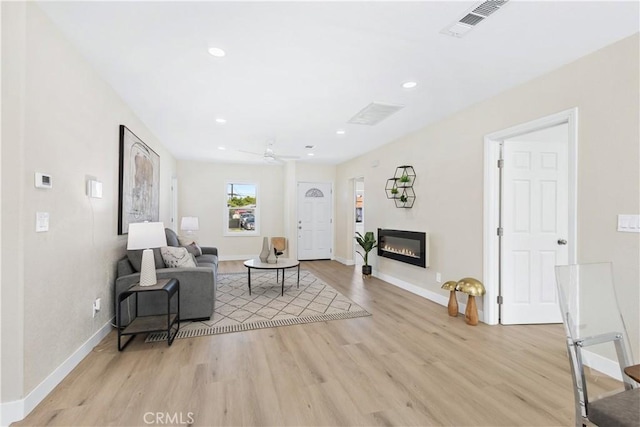 3876 Olmsted Ave, Los Angeles, CA 90008 - living area featuring light wood finished floors, a glass covered fireplace, recessed lighting, and a ceiling fan