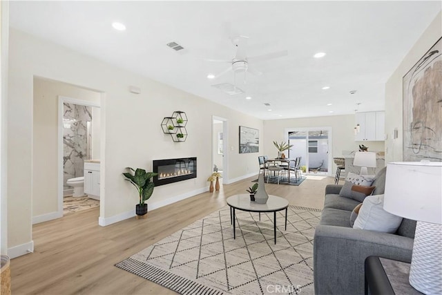 3876 Olmsted Ave, Los Angeles, CA 90008 - living room featuring light wood-type flooring, a ceiling fan, recessed lighting, and a glass covered fireplace