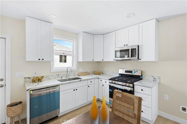 3876 Olmsted Ave, Los Angeles, CA 90008 - kitchen with stainless steel appliances, light stone countertops, white cabinetry, and recessed lighting
