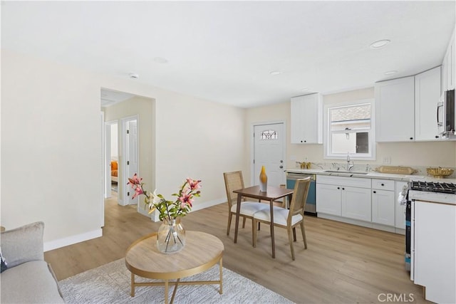 3876 Olmsted Ave, Los Angeles, CA 90008 - kitchen with appliances with stainless steel finishes, light wood finished floors, white cabinetry, light countertops, and recessed lighting