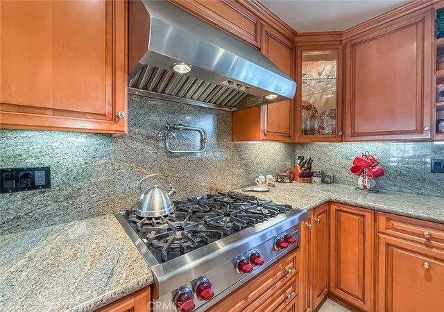 17213 Horace St, Granada Hills, CA 91344 - kitchen with extractor fan, stainless steel gas stovetop, brown cabinetry, and glass insert cabinets