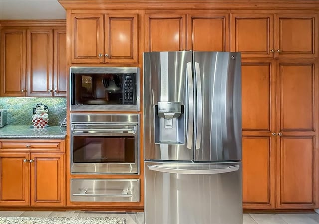 17213 Horace St, Granada Hills, CA 91344 - kitchen featuring stainless steel appliances, a warming drawer, brown cabinetry, tasteful backsplash, and light tile patterned floors