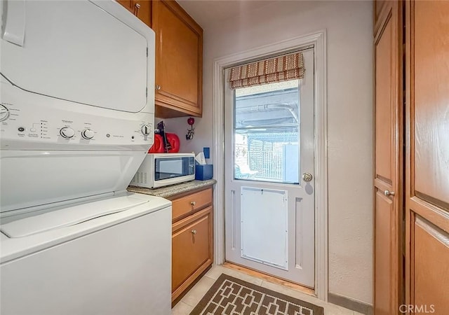 17213 Horace St, Granada Hills, CA 91344 - laundry area with stacked washer and clothes dryer, cabinet space, and light tile patterned flooring