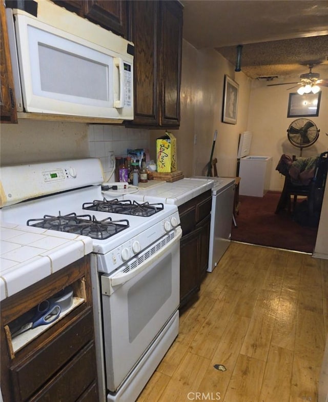 1239 W Rosecrans, Gardena, CA 90247 - kitchen with white appliances, tile countertops, dark brown cabinets, and light wood-type flooring