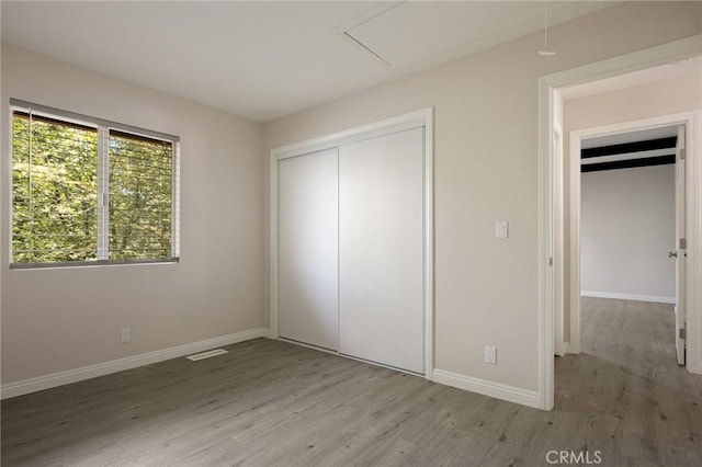 833 E Victoria, Lake Arrowhead, CA 92352 - unfurnished bedroom with wood finished floors, attic access, and a closet
