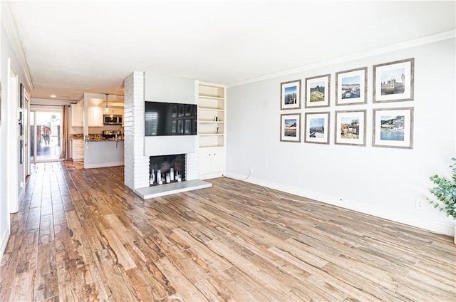 1209 E 1st St, Tustin, CA 92780 - unfurnished living room with ornamental molding, light wood-style floors, and a fireplace
