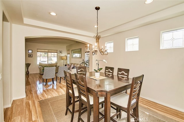 13637 Aspen Leaf Ln, Eastvale, CA 92880 - dining space with arched walkways, recessed lighting, a tray ceiling, and light wood finished floors