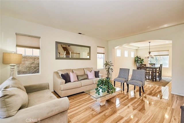 13637 Aspen Leaf Ln, Eastvale, CA 92880 - living area featuring arched walkways, light wood finished floors, and a chandelier
