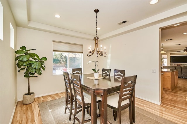 13637 Aspen Leaf Ln, Eastvale, CA 92880 - dining area with light wood finished floors, a raised ceiling, recessed lighting, and a chandelier