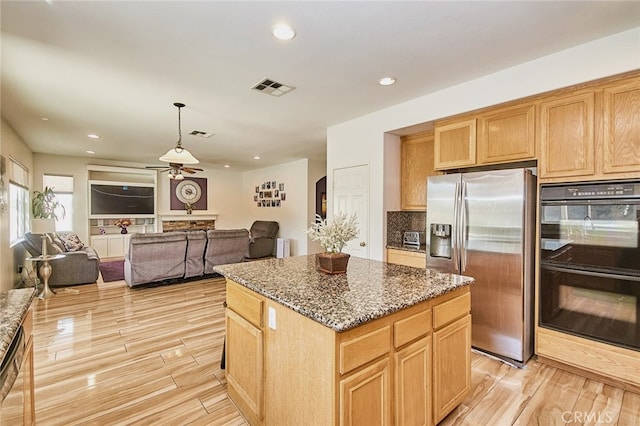 13637 Aspen Leaf Ln, Eastvale, CA 92880 - kitchen with stainless steel refrigerator with ice dispenser, ceiling fan, dark stone counters, open floor plan, and recessed lighting