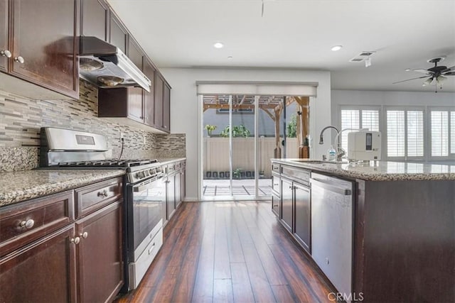 16202 Orion Ave, Chino, CA 91708 - kitchen with appliances with stainless steel finishes, under cabinet range hood, a ceiling fan, tasteful backsplash, and dark wood finished floors