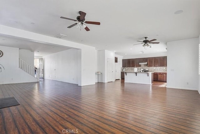 16202 Orion Ave, Chino, CA 91708 - unfurnished living room featuring a ceiling fan, dark wood-style flooring, and stairs