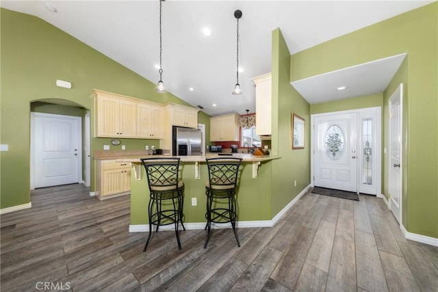 5935 Monte Vista Rd, Phelan, CA 92371 - kitchen featuring stainless steel fridge with ice dispenser, a kitchen bar, arched walkways, dark wood-type flooring, and high vaulted ceiling