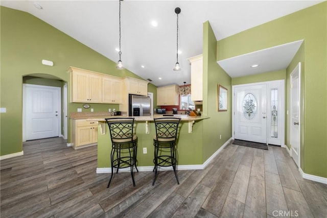 5935 Monte Vista Rd, Phelan, CA 92371 - kitchen with stainless steel refrigerator with ice dispenser, dark wood-style flooring, arched walkways, a kitchen bar, and high vaulted ceiling