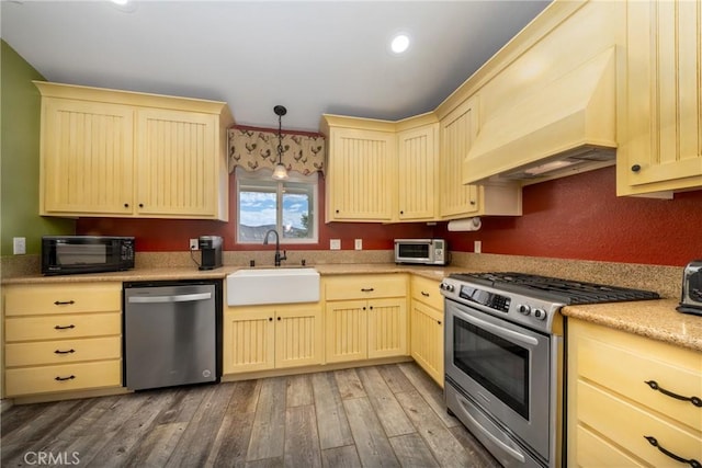 5935 Monte Vista Rd, Phelan, CA 92371 - kitchen with stainless steel appliances, cream cabinetry, light wood-style floors, light countertops, and premium range hood