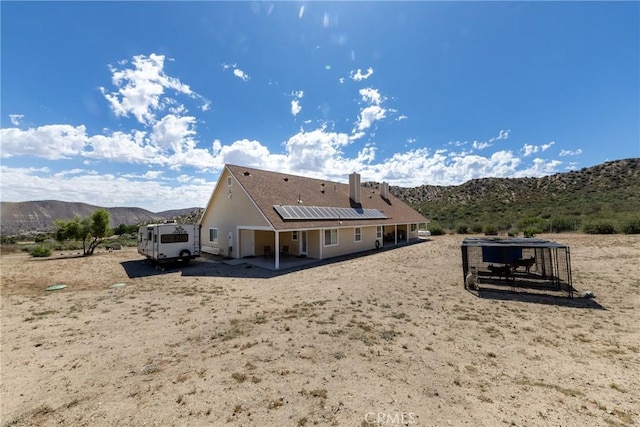 5935 Monte Vista Rd, Phelan, CA 92371 - back of house with solar panels, a mountain view, and a patio area