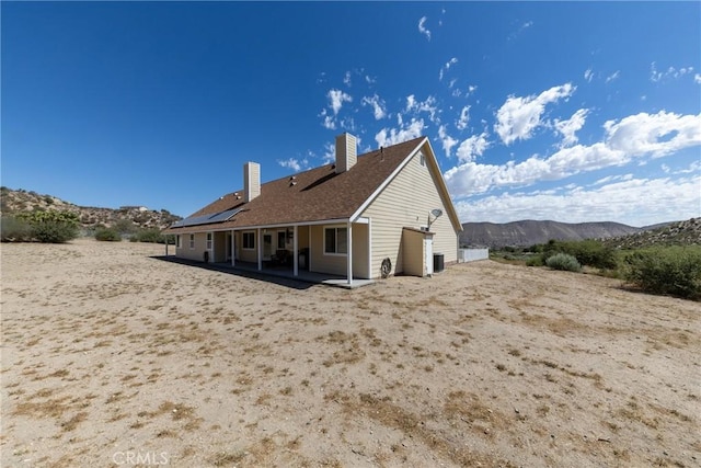 5935 Monte Vista Rd, Phelan, CA 92371 - rear view of property with a chimney, a mountain view, a patio, and solar panels