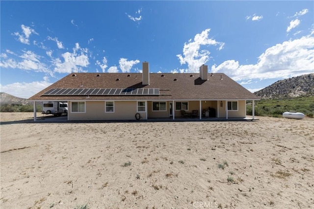 5935 Monte Vista Rd, Phelan, CA 92371 - rear view of property with solar panels, a patio area, a mountain view, and a chimney