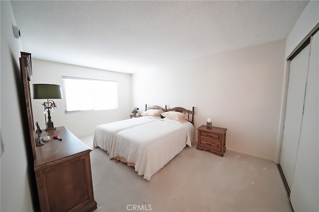 18560 Vanowen St Unit 27, Reseda, CA 91335 - bedroom with light colored carpet, a closet, and a textured ceiling